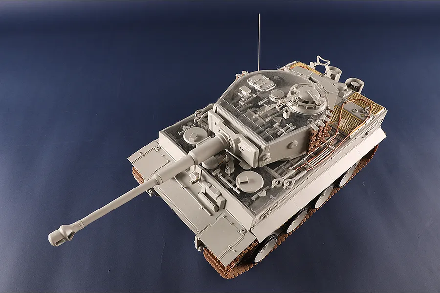 A high-angle view of a 1/16 scale Tiger I tank model kit with a clear plastic turret section showing internal details.