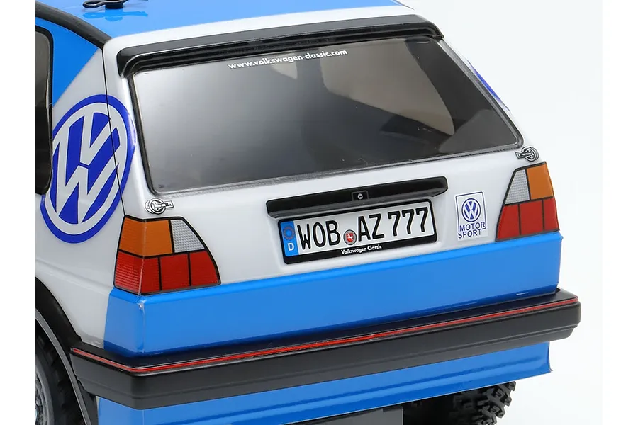 Rear view of a Tamiya Volkswagen Golf MK2 GTI RC car body featuring blue and white livery, Volkswagen branding, and a German license plate.
