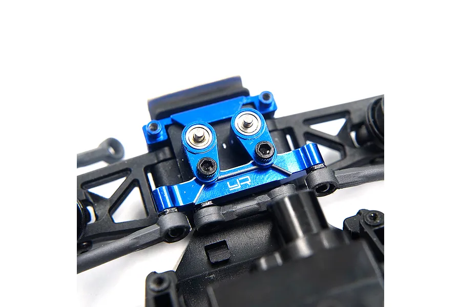 Close-up of a blue anodized aluminium steering assembly installed on a black plastic RC car chassis.