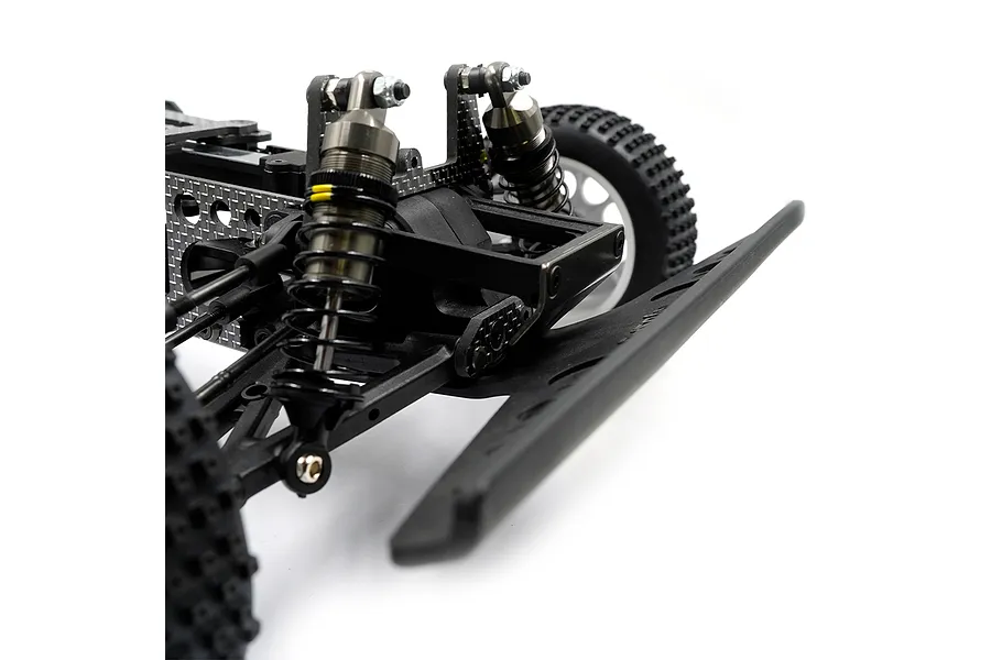 Close-up of the front suspension and chassis of an RC buggy, featuring graphite shock towers, metal oil-filled shocks, and a black plastic front bumper.