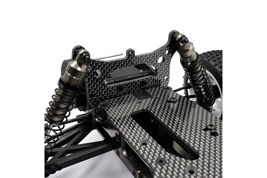 Close-up of a carbon fiber RC car chassis upgrade set with shock absorbers and suspension components on a white background.