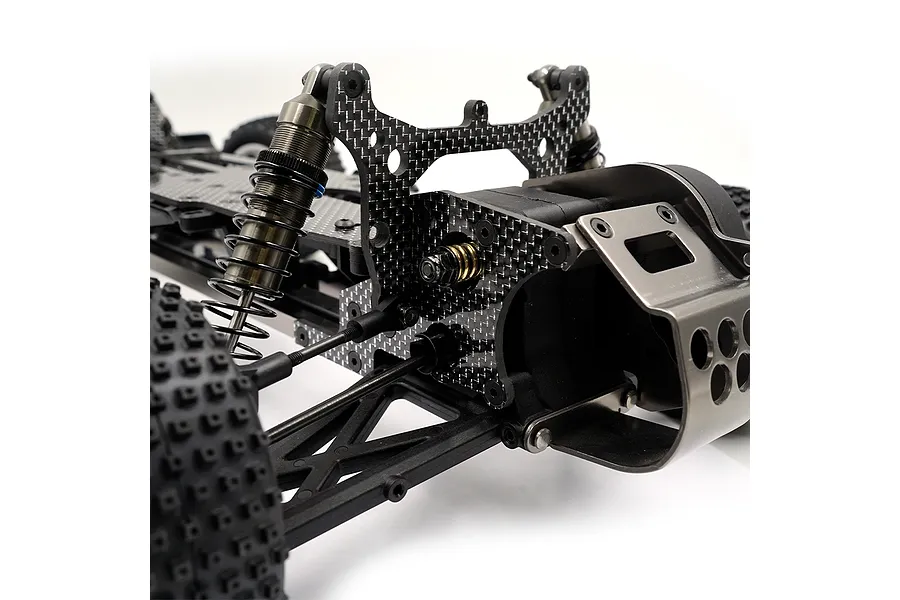 Close-up of the rear chassis section of an RC car featuring a carbon fiber shock tower and metal rear bumper brace.