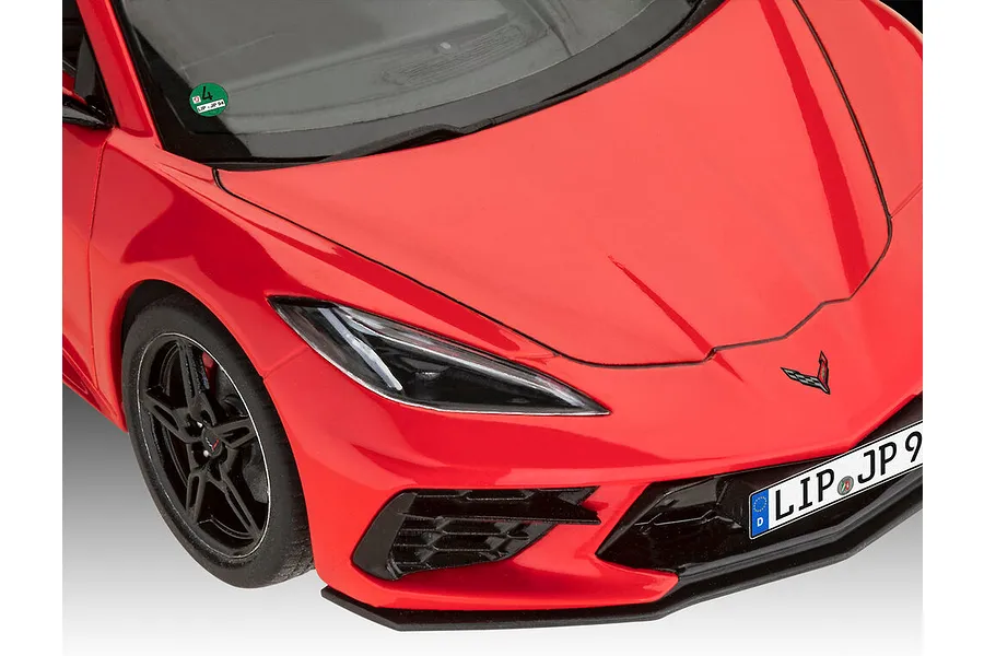 Close-up of a red Revell 1/25 scale Corvette C8 model car showing the hood, headlight, and front bumper with German license plate.