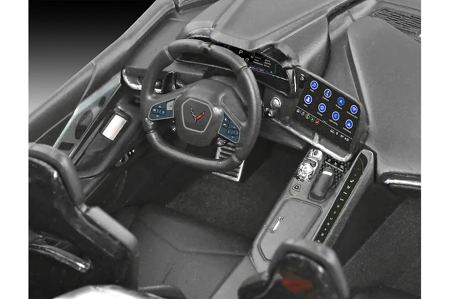 Close-up of the detailed interior of a 1/25 scale Revell Corvette C8 model car, showing the dashboard, steering wheel, and center console.