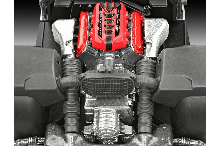 Close-up top-down view of the detailed engine bay of a 1/25 scale Revell Corvette C8 model kit, featuring a red engine cover with Corvette branding.