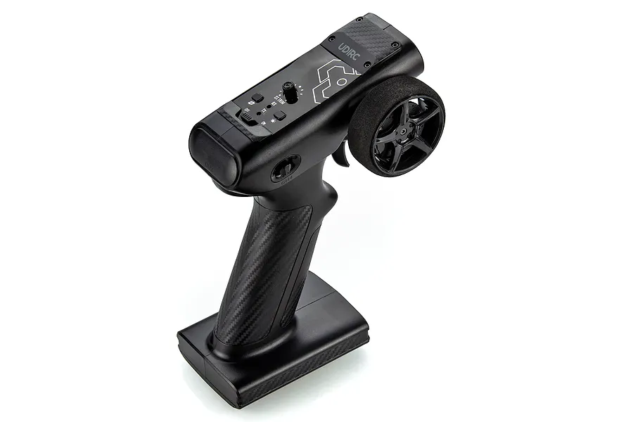 A black UDI RC pistol-grip transmitter for RC boats, featuring a steering wheel, throttle trigger, and various adjustment switches.