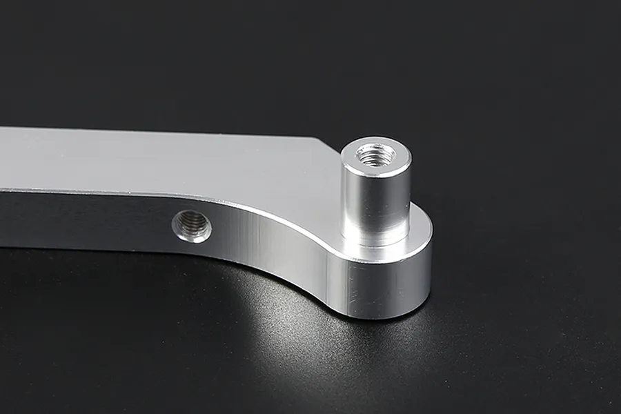Close-up of a silver Rovan aluminium engine mount part against a black background.