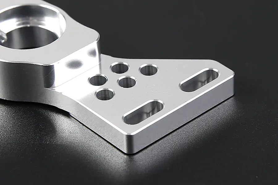 Close-up of a silver Rovan aluminium first stage small gear mount on a dark background.