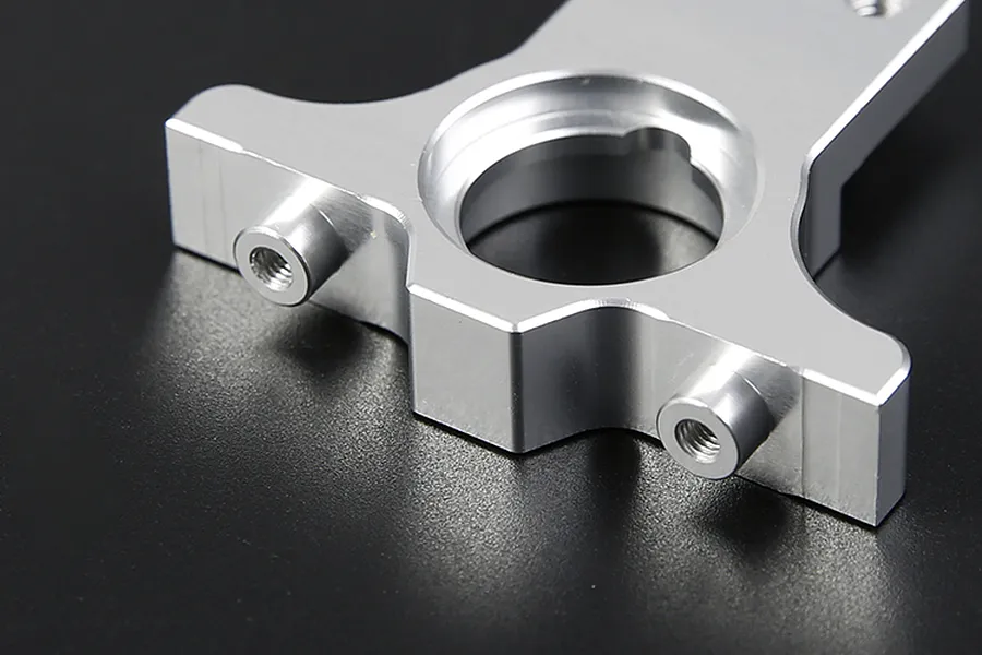 Close-up of a silver aluminium RC gear mount component on a black background.