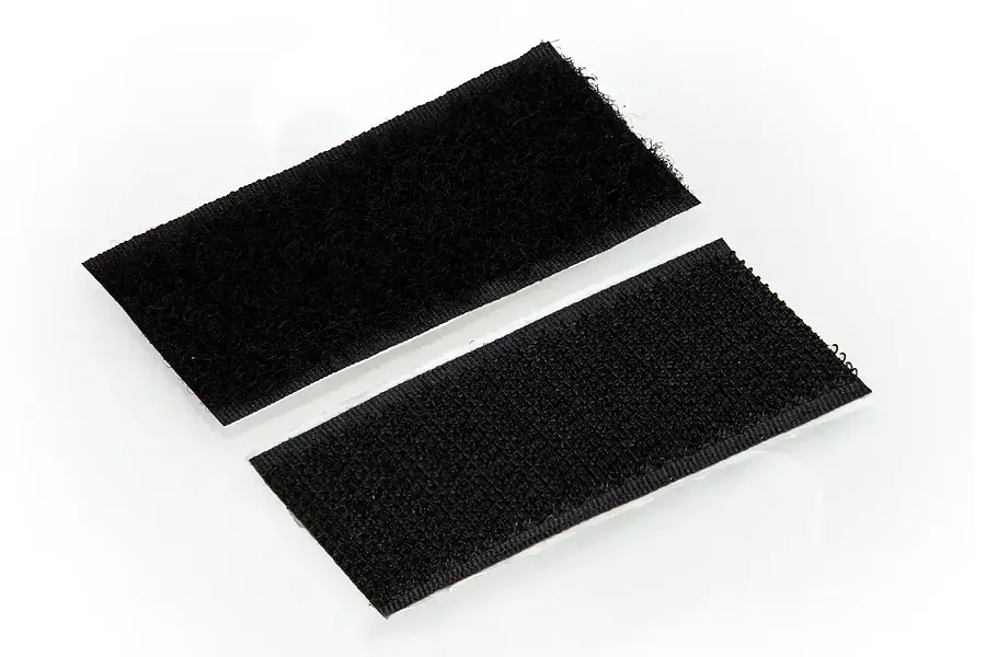 Two rectangular strips of black adhesive-backed hook and loop fastener tape on a white background.