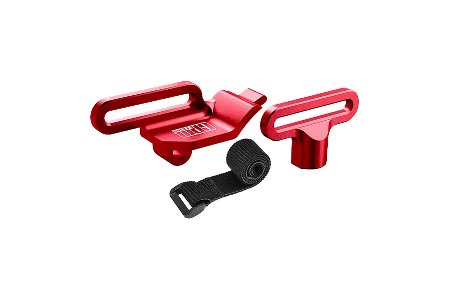 A set of red anodized aluminium battery mounts and a black velcro strap for RC cars by GPM Racing.