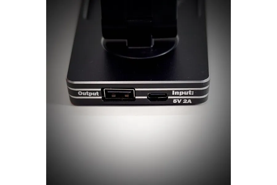 Close-up of the base of a Team Powers LED Pit Light Pro showing the USB output and micro-USB input ports on a black metal housing.