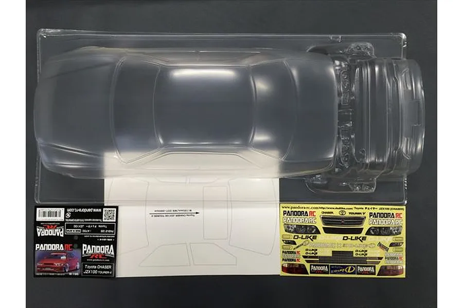Top-down view of an unpainted clear polycarbonate RC car body shell for a Toyota Chaser JZX100, including decal sheet and product label.