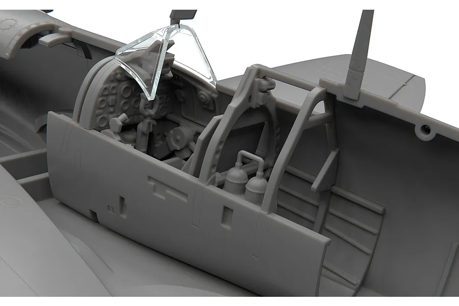 Close-up of the detailed cockpit interior of an unpainted 1/48 scale Supermarine Spitfire plastic model kit.