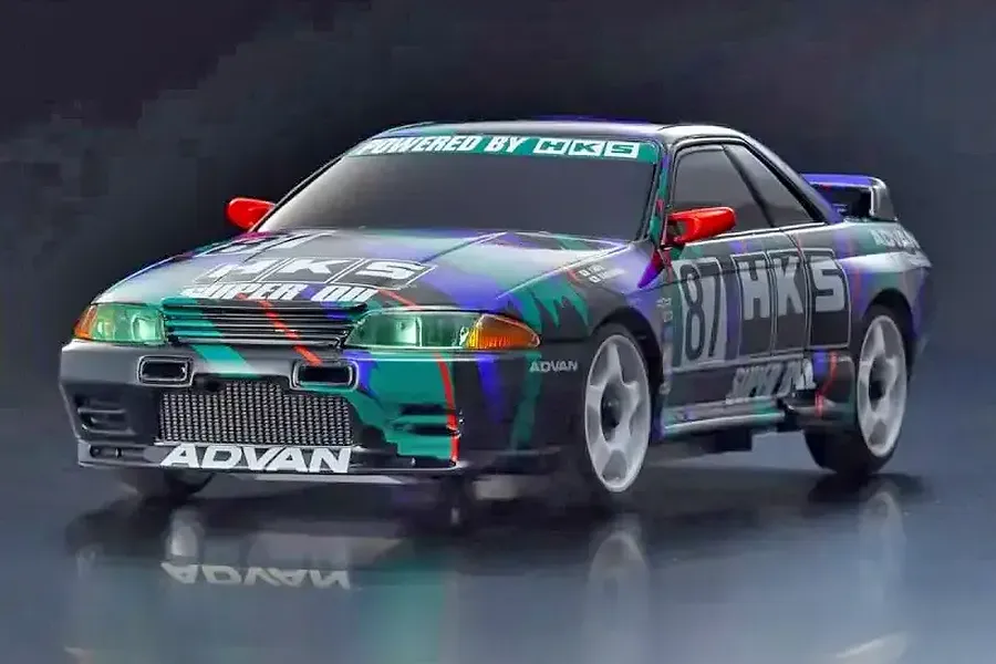 A studio shot of a Kyosho Mini-Z Nissan Skyline GT-R R32 RC car featuring the iconic HKS racing livery in black, purple, and teal.