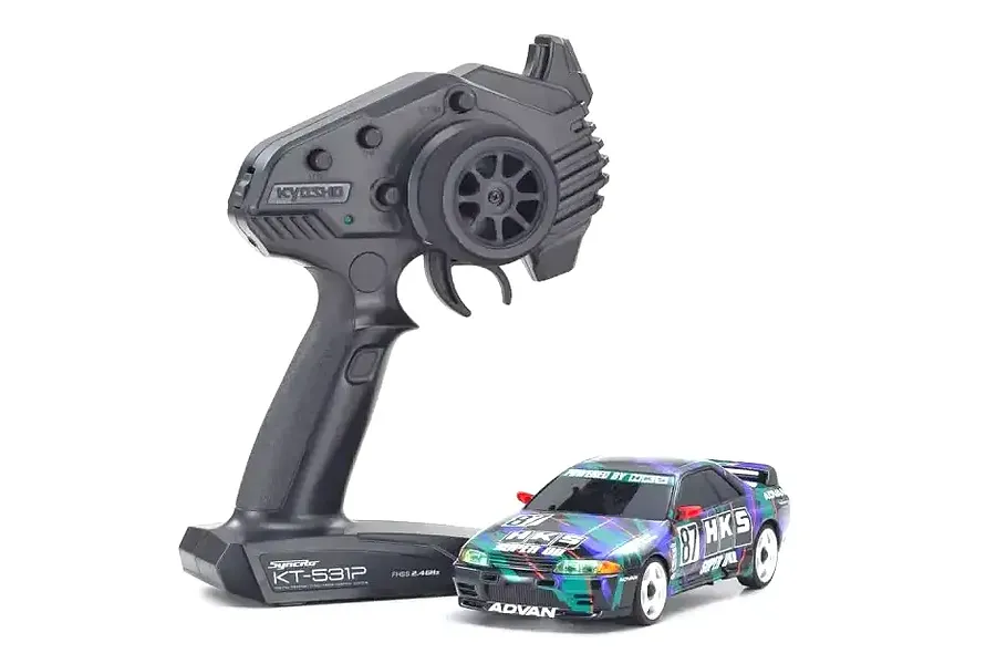 Kyosho Mini-Z Nissan Skyline GT-R R32 HKS drift car with its black KT-531P pistol-grip radio transmitter on a white background.