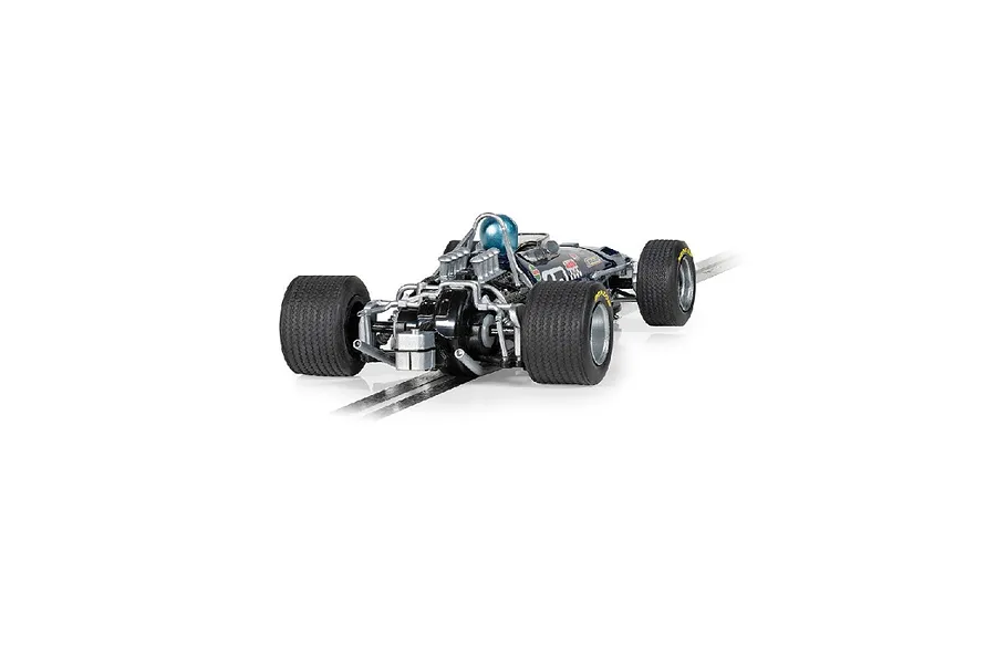 Rear view of a 1/32 scale Scalextric Brabham BT26 slot car in dark blue, showing the engine detail, driver helmet, and wide rear tires on a track section.