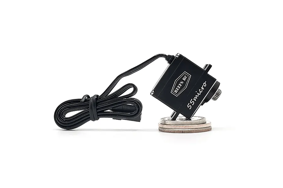 Reefs RC 55Micro sub-micro servo in black, resting on a coin for scale against a white background.