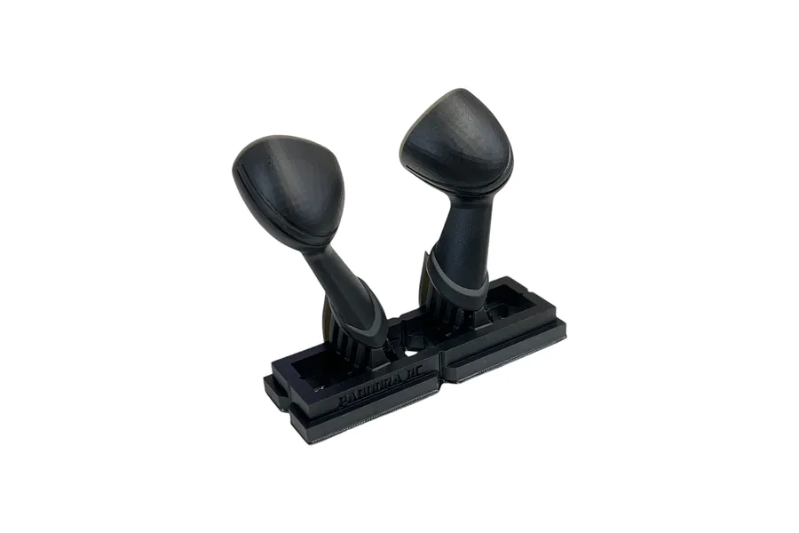 A pair of black 1/10 scale RC fender mirrors by Pandora RC, attached to a plastic mounting base against a white background.