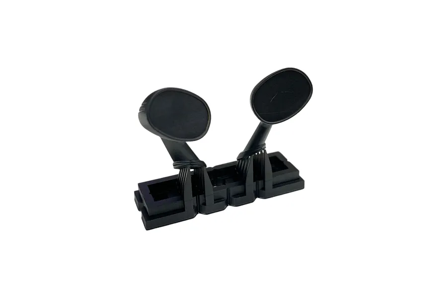 A pair of black 1/10 scale RC fender mirrors attached to a plastic sprue frame against a white background.