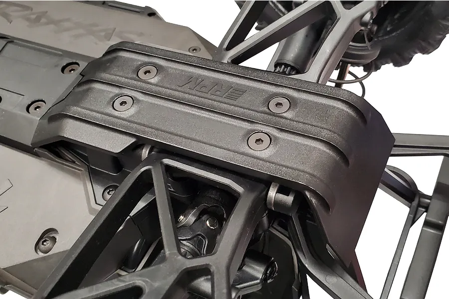 Close-up of a black RPM brand rear skid plate installed on an RC vehicle chassis, showing the mounting screws and textured plastic surface.