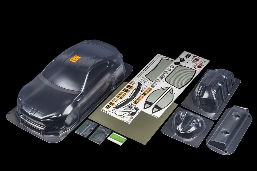 HPI Racing 1/10 scale clear Toyota GT86 RC car body shell with included decal sheet, wing, and accessory parts on a black background.