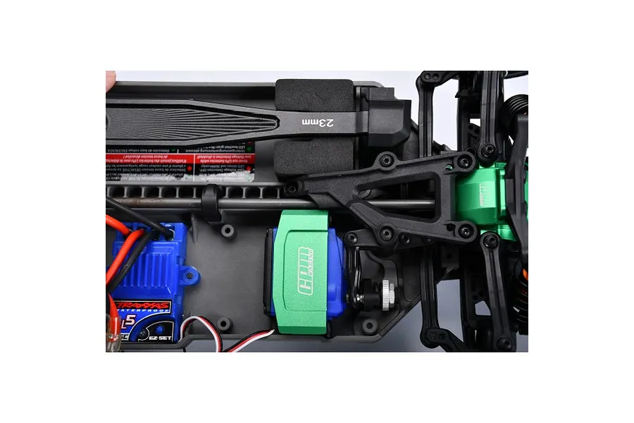 Top-down view of an RC car chassis showing a green GPM Racing aluminium servo mount installed over a blue servo.