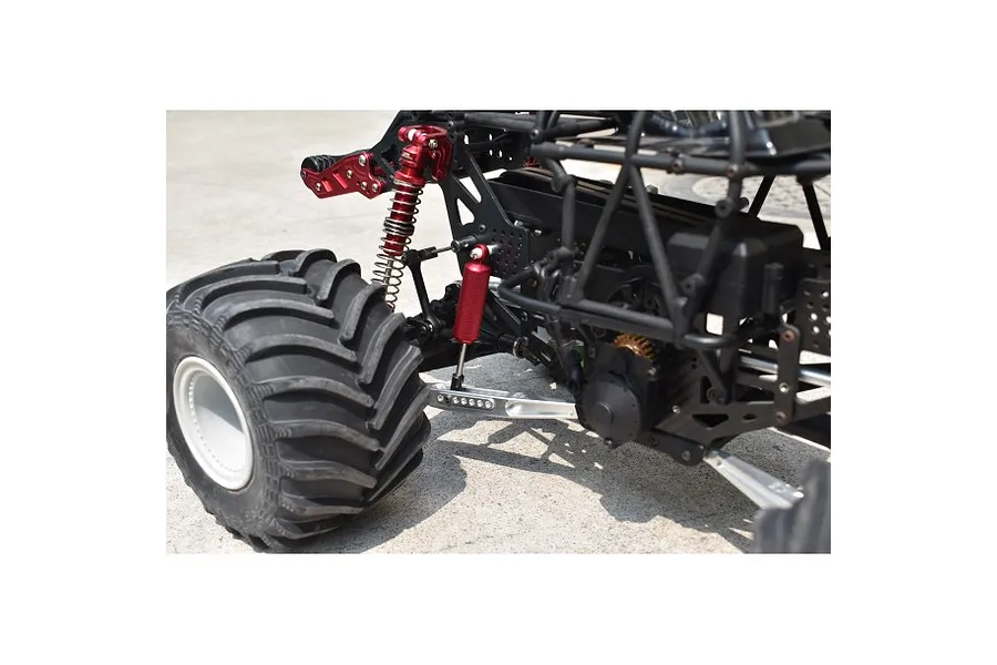 Close-up of the rear suspension and silver lower link bars installed on an RC monster truck chassis.