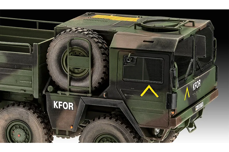 A detailed close-up of a 1/35 scale Revell MAN 10T Milgl 8x8 military truck model, featuring camouflage paint, KFOR markings, and a spare tire.