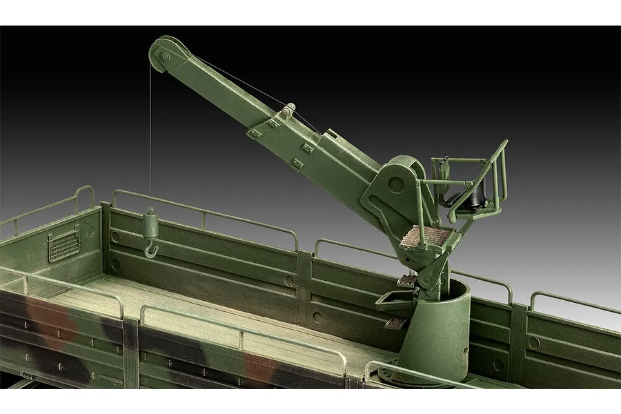 A close-up view of a green military truck model kit featuring a mounted crane assembly in the cargo bed.