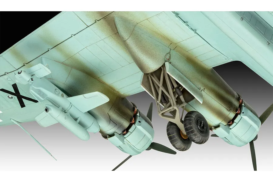 Close-up of the underside of a scale model Focke-Wulf Fw 200 aircraft showing landing gear, engine nacelles, and an external payload.