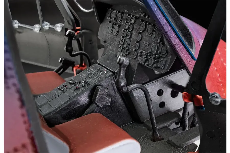 Close-up view of the detailed cockpit interior of a 1/32 scale Bell UH-1D model helicopter, showing instrument panels, control sticks, and seats.