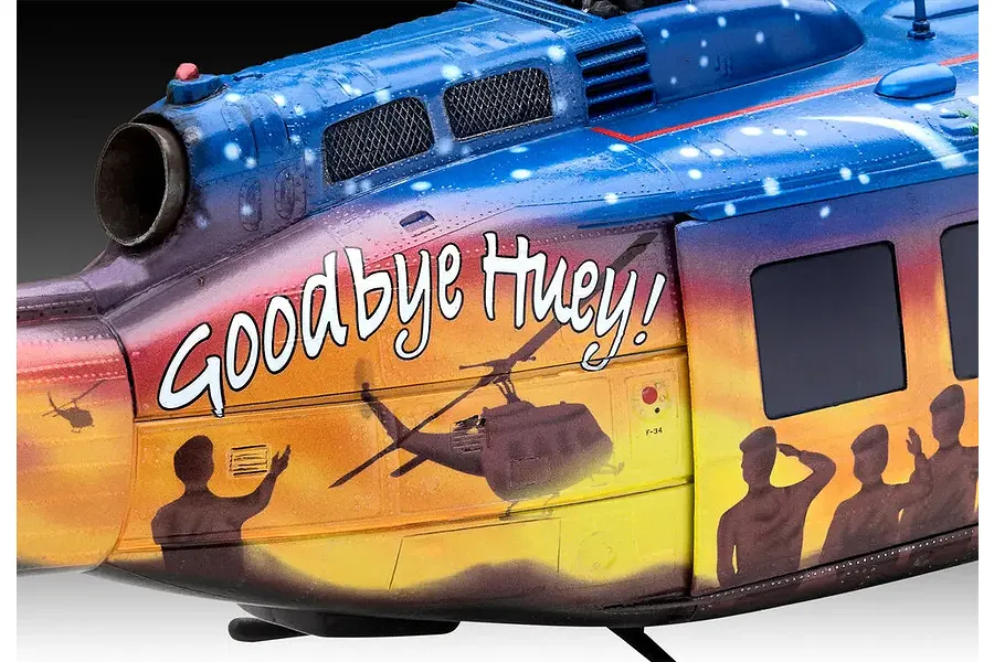 Close-up of the side of a Revell 1/32 Bell UH-1D Goodbye Huey model helicopter featuring a sunset-themed paint scheme with silhouettes of soldiers and text.