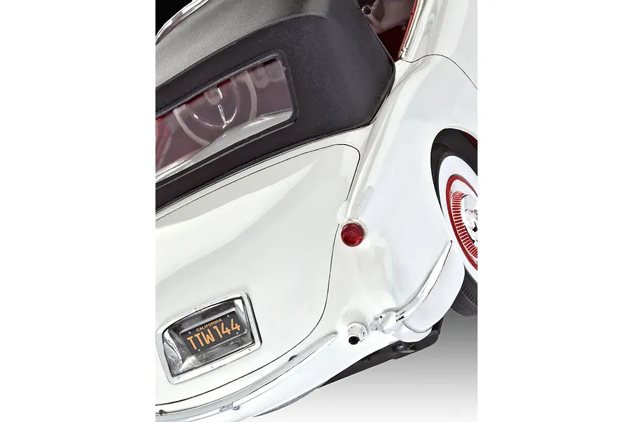 Close-up of the rear quarter of a white 1953 Chevrolet Corvette model car showing the black convertible top, California license plate, and chrome bumper.