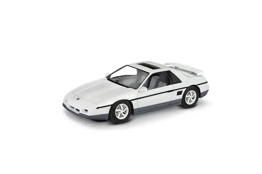 A white 1985 Pontiac Fiero GT model car on a white background, showing the exterior, wheels, and spoiler.