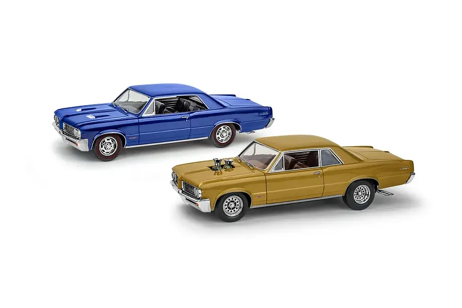 Two assembled 1/24 scale 1964 Pontiac GTO model cars, one in metallic blue and one in metallic gold, displayed against a white background.