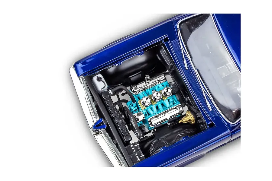 A high-angle close-up of the detailed engine bay of a blue 1964 Pontiac GTO model car kit, showing the turquoise engine block and chrome components.
