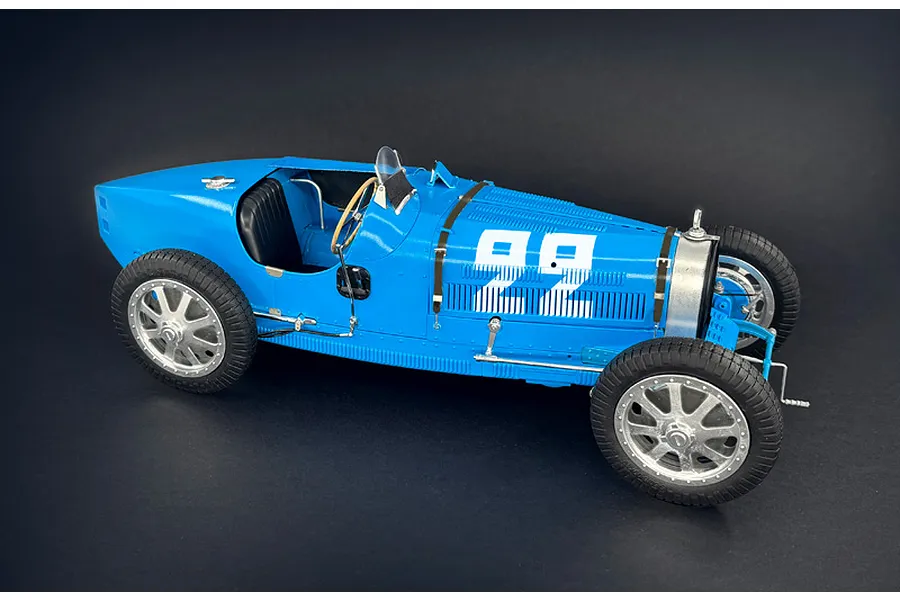 A 1/12 scale model of a blue Bugatti Type 35B race car with the number 22 on the side, displayed against a dark background.