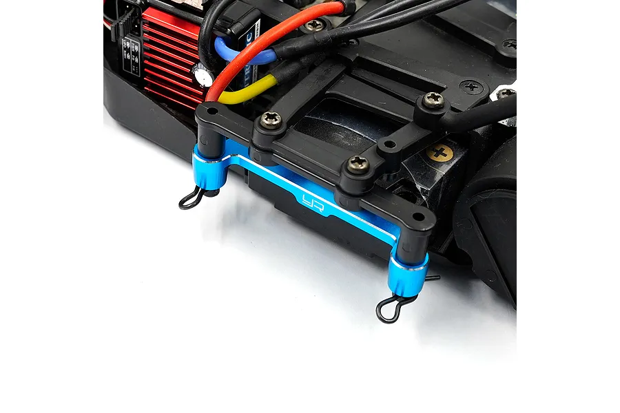 A blue anodized aluminium battery mount installed on an RC car chassis, featuring the Yeah Racing logo.