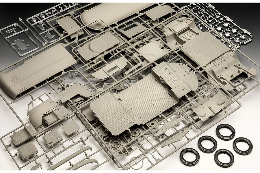 Plastic model kit sprues for a 1/16 scale VW T1 Panel Van, showing grey body panels, interior parts, clear windows, chrome hubcaps, and black rubber tires.