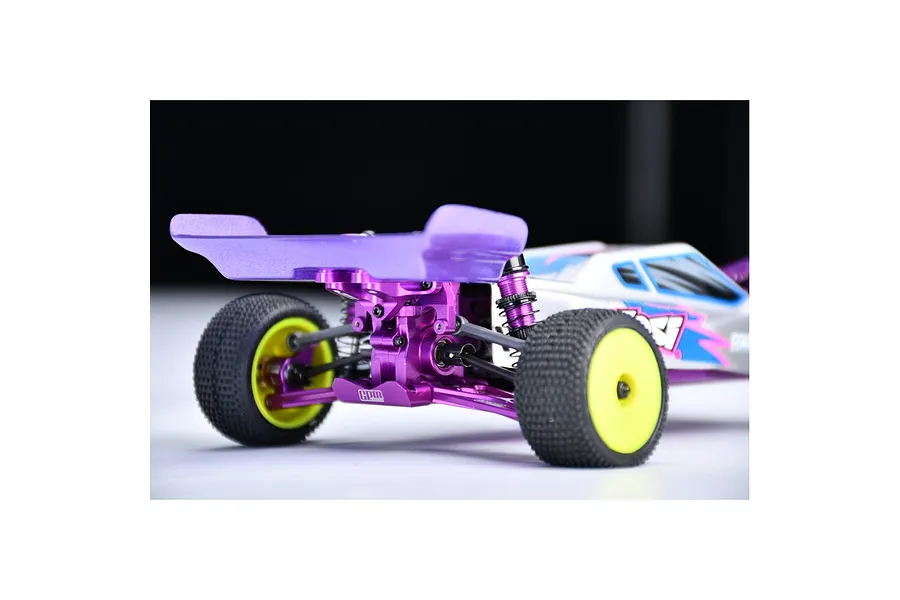 Rear view of an RC buggy featuring a purple GPM Racing aluminium wing mount and rear wing installed on the chassis.