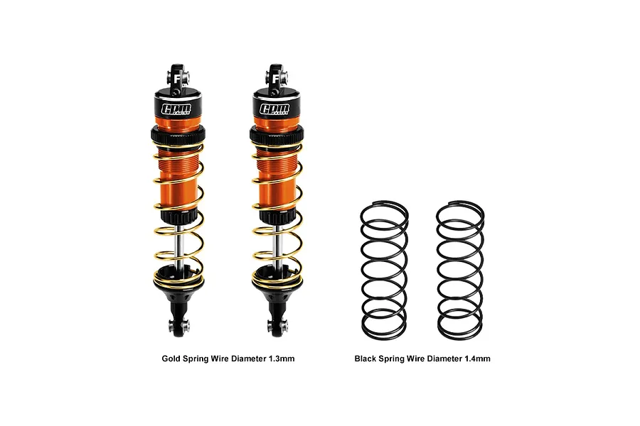 Two GPM Racing orange aluminium adjustable front RC shocks with gold springs, alongside two additional black replacement springs on a white background.