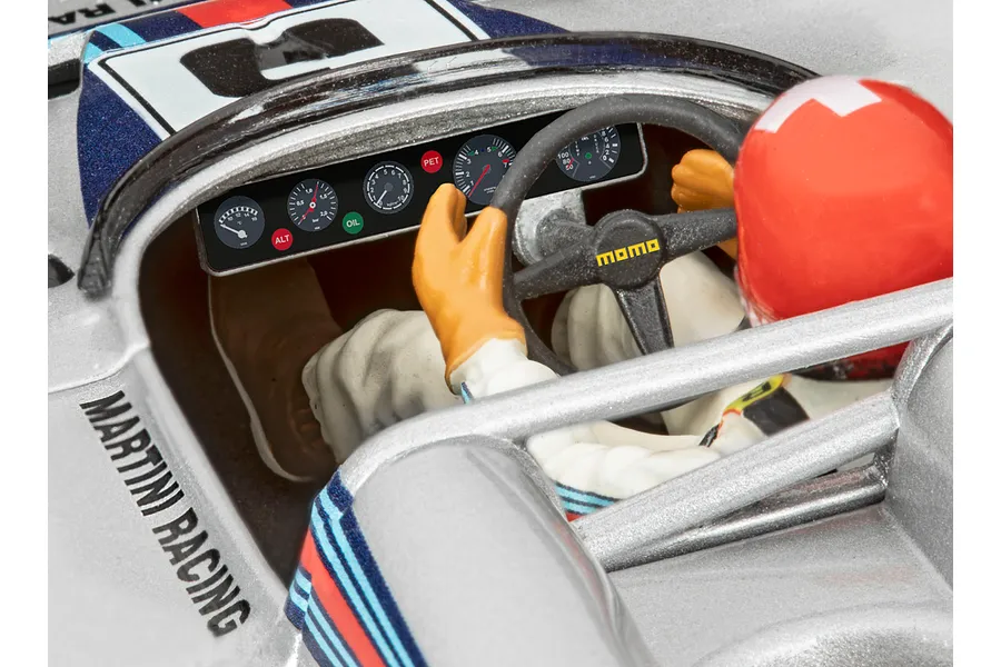 Close-up of the cockpit of a Revell 1/32 Porsche 917 model car, showing the driver figure, dashboard gauges, and Momo steering wheel.