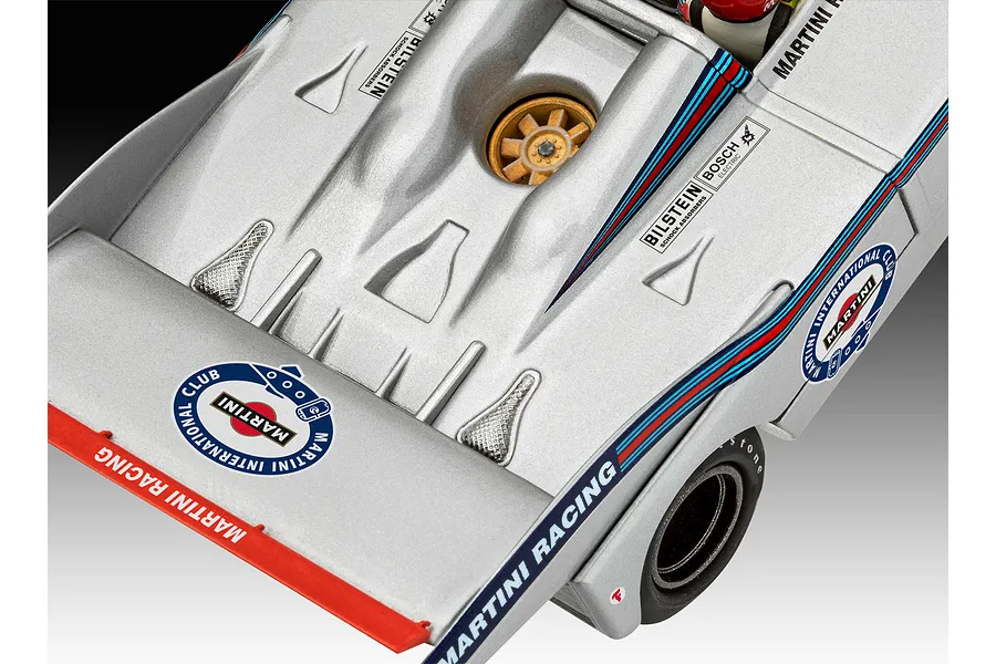 Close-up of a silver Porsche 917 model race car featuring Martini Racing livery, decals, and a gold-colored wheel hub.