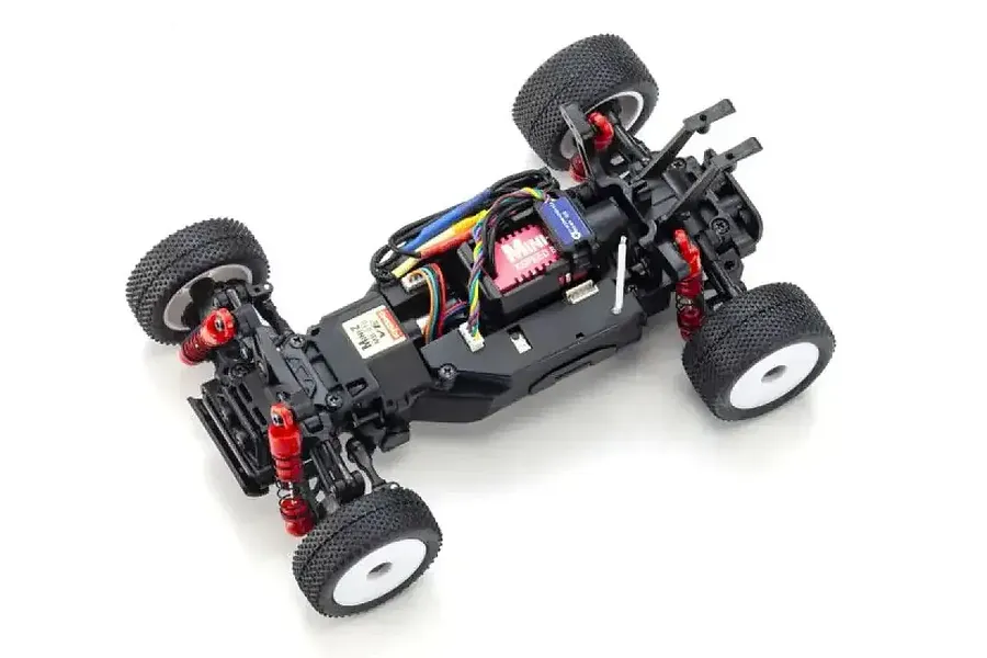 Top-down view of a Kyosho Mini-Z MB-010VE 2.0 RC buggy chassis with black frame, red shock absorbers, and off-road tires.