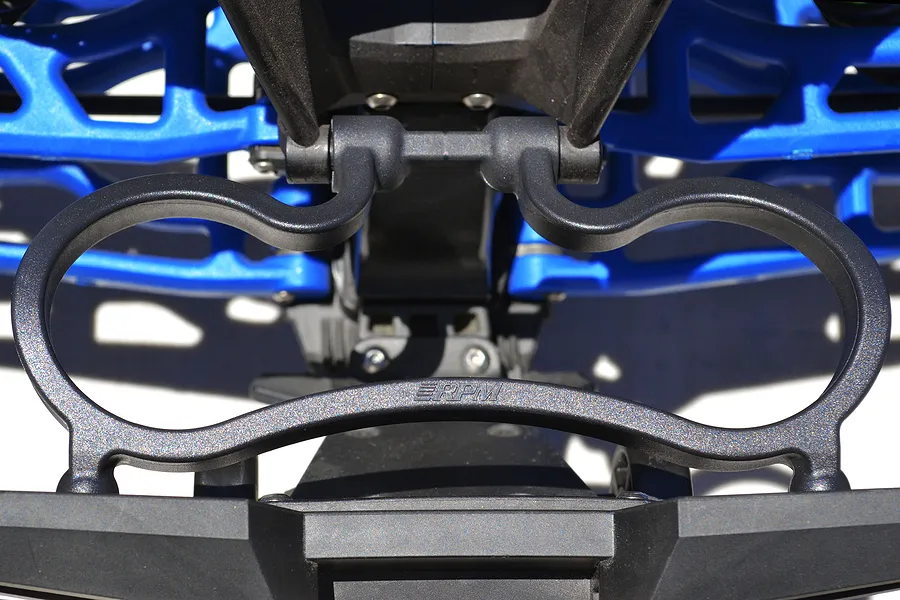 Close-up of an RPM rear bumper mount installed on an RC vehicle chassis, featuring a black plastic guard with the RPM logo.