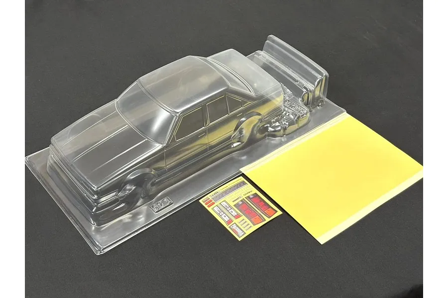 A clear, unpainted 1/10 scale RC Toyota Carina A63 body shell from Pandora RC, including a decal sheet and masking film on a black surface.