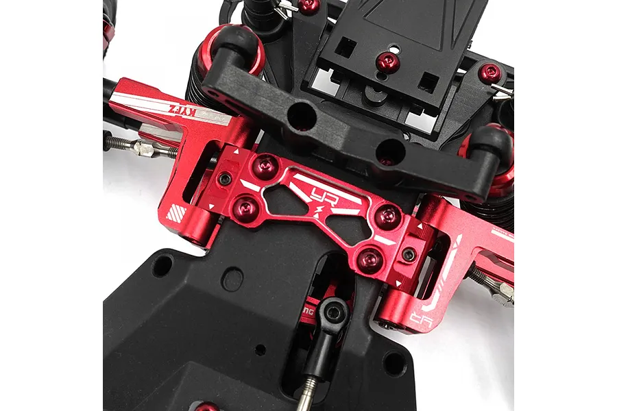 Close-up of a red anodized aluminium upper suspension arm mount installed on an RC car chassis.