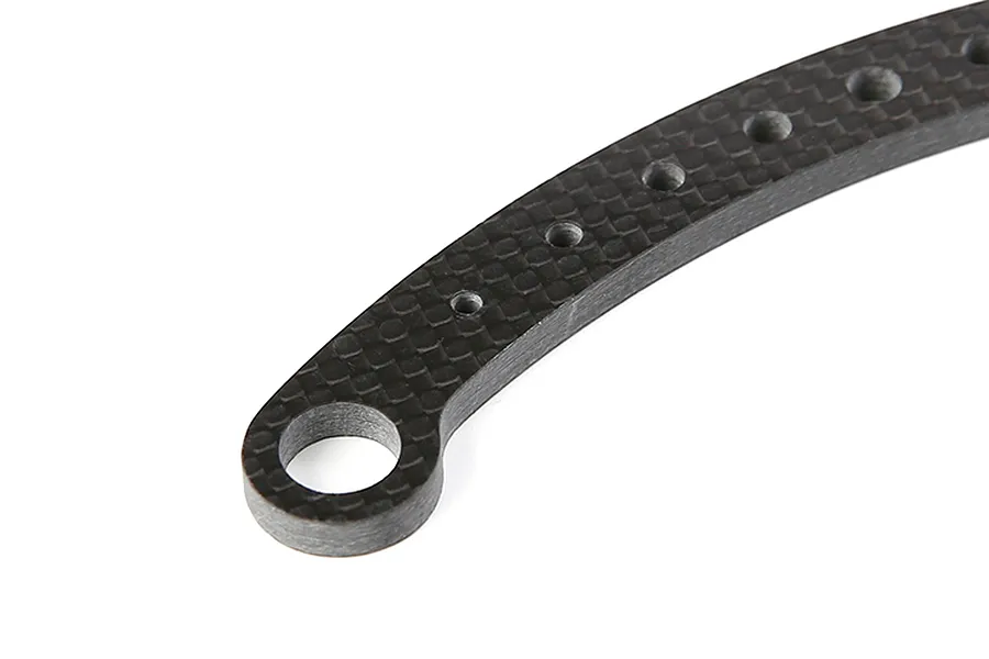 Close-up of a curved carbon fibre steering plate with multiple mounting holes.