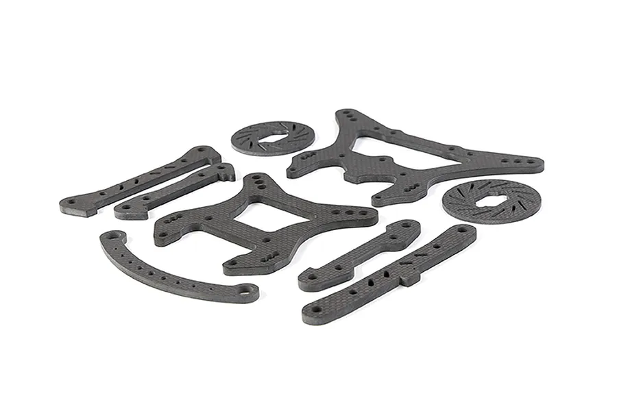 A set of Rovan carbon fibre RC car parts including shock towers, braces, and brake discs arranged on a white background.